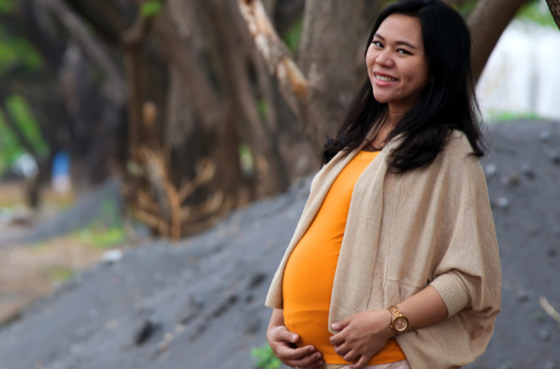 pregnant woman smiling in the outdoors