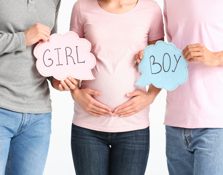 two parents holding boy or girl signs and a pregnant surrogate mother in between them
